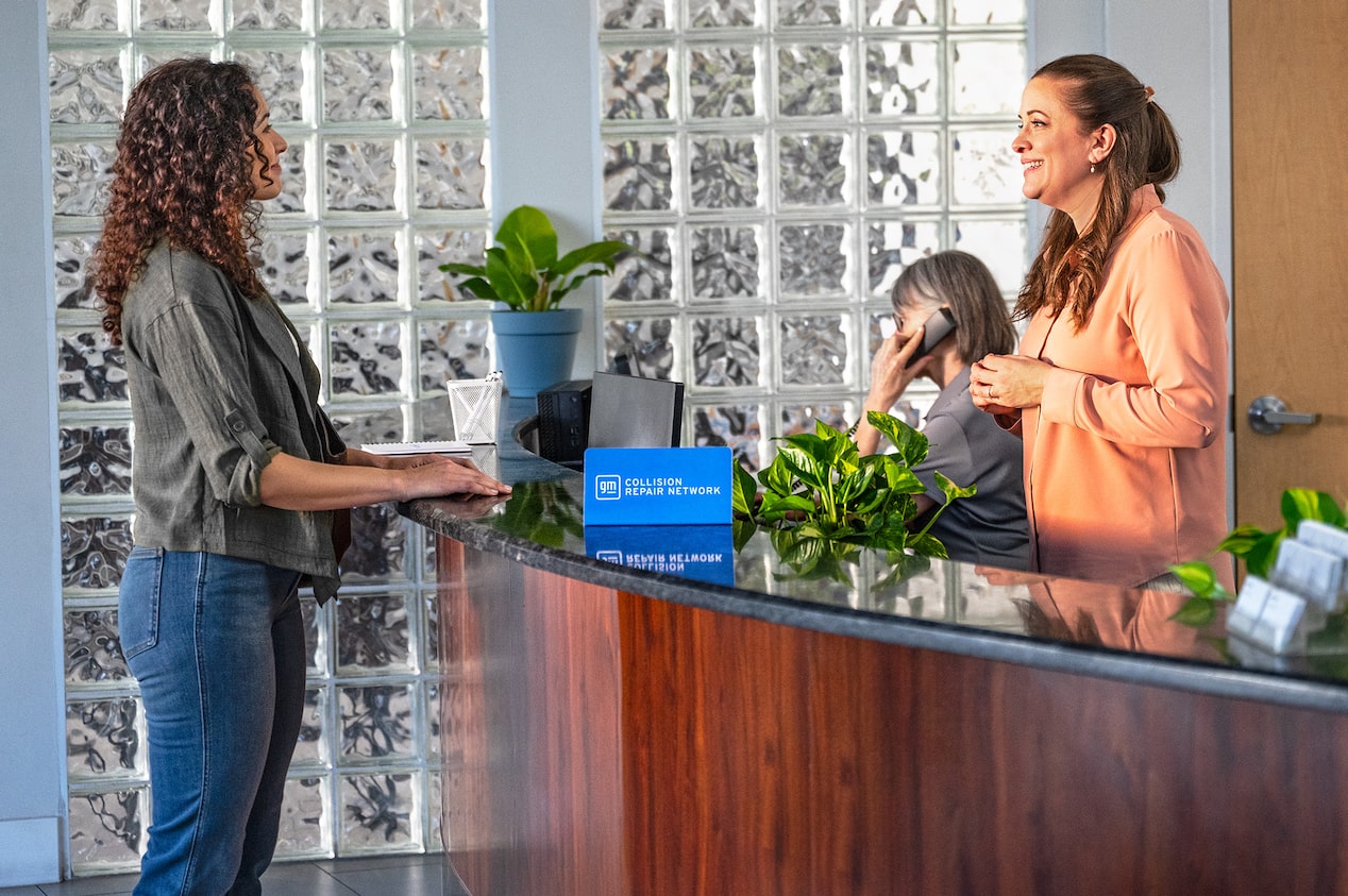 A Woman Speaking to Another Woman Standing Behind a Desk