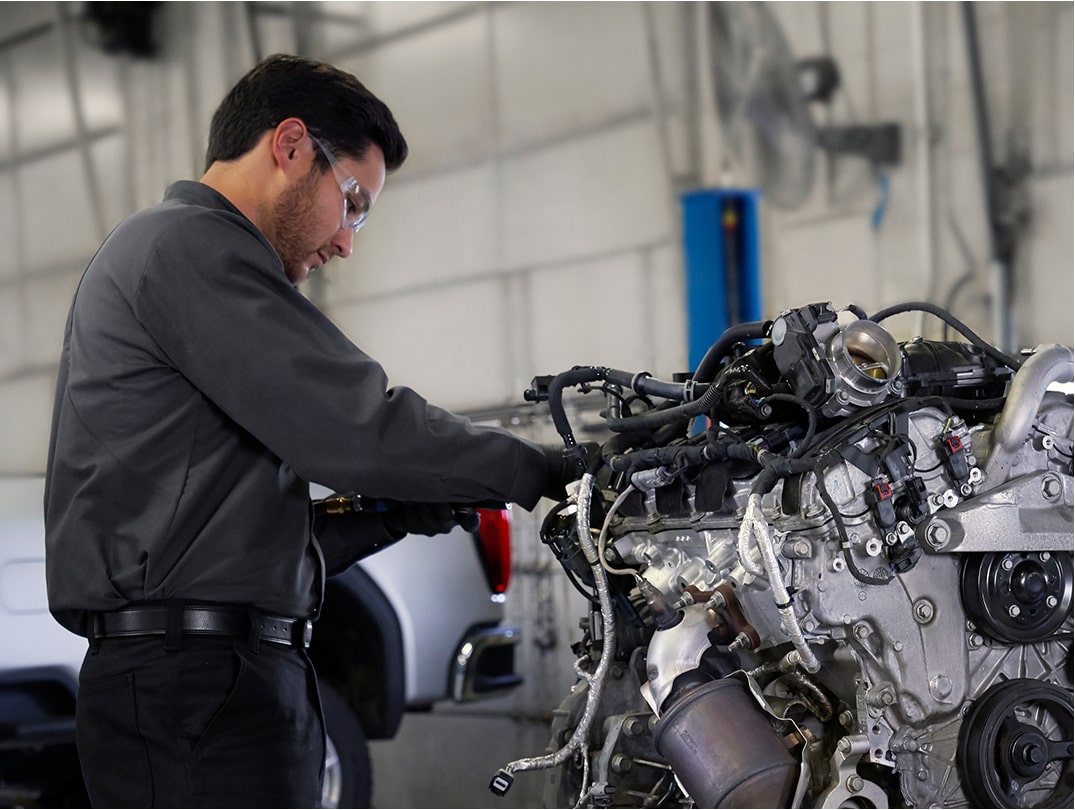 Automotive Technician Working On A Vehicle Engine In A Shop