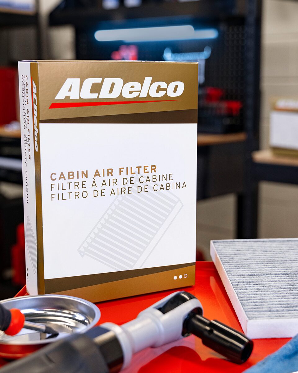 ACDelco Gold Cabin Air Filter Lying on a Table Next to Various Parts