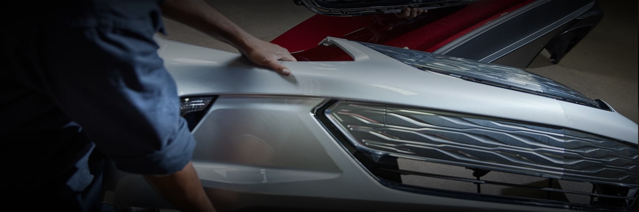 Two Technicians Working to Assemble Front Grille and Bumper Cover Parts Together