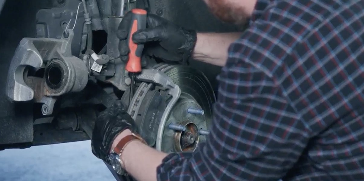 A Mechanic is Seen Working on a Rotor’s Brake System