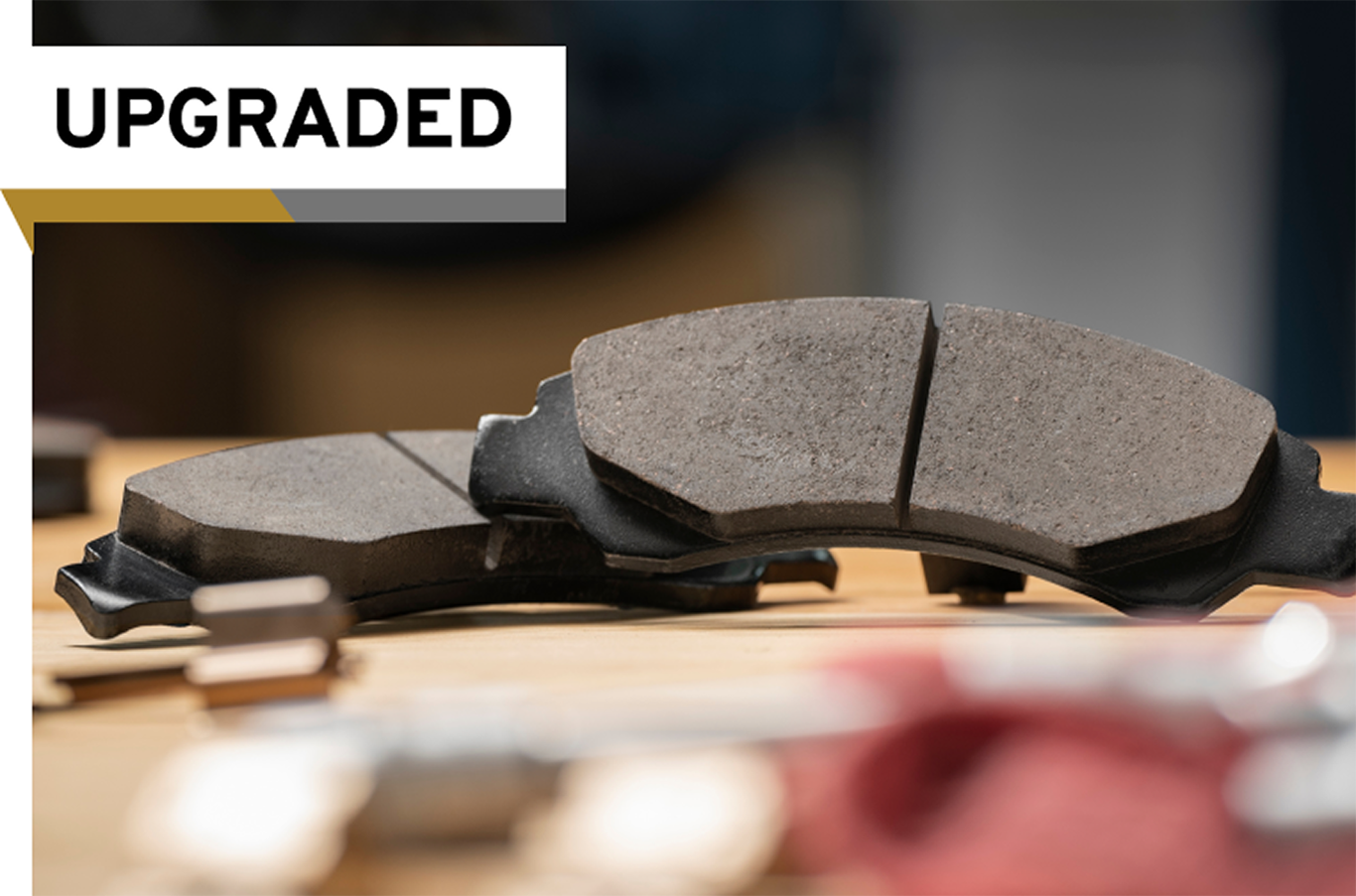 A Pair of Improved Disc Brake Pads Set on a Table With an "Upgraded" Label on the Image.