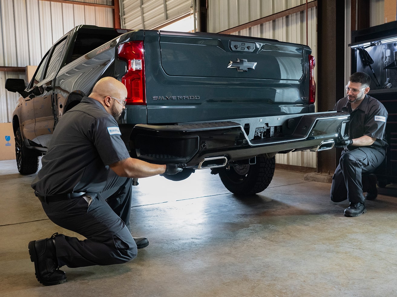 A Service Technician Working on the Rear Side of a GMC Truck