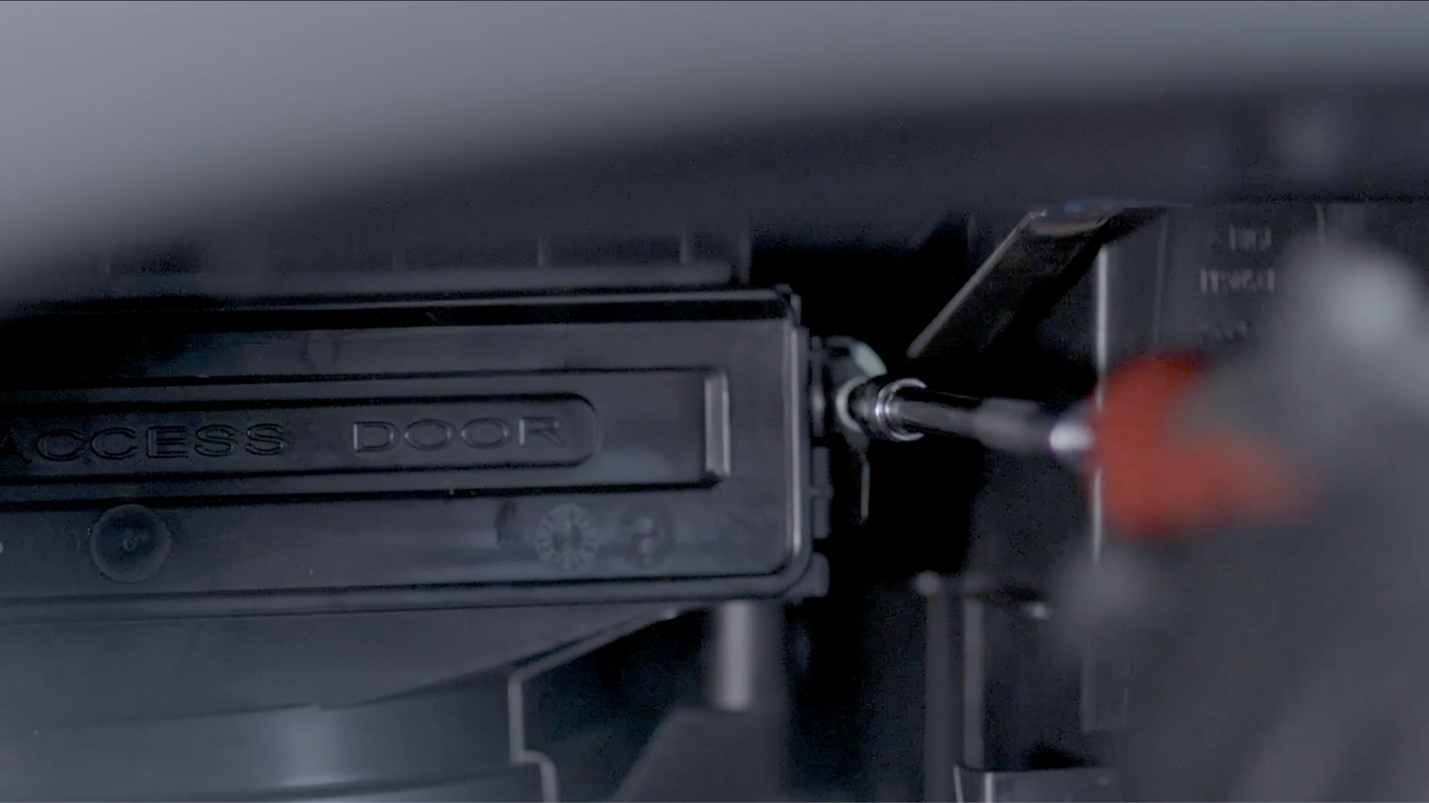 A Close-up View of a Technician Screwing the Filter Box Closed.