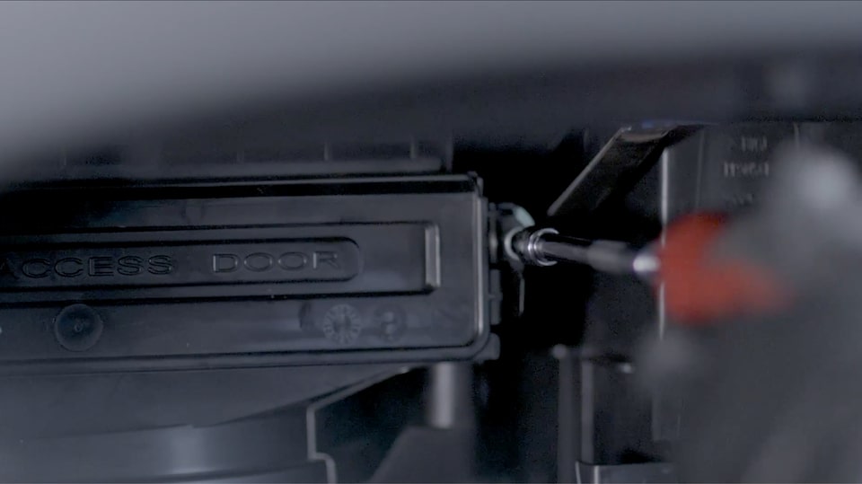 A Close-up View of a Technician Screwing the Filter Box Closed.