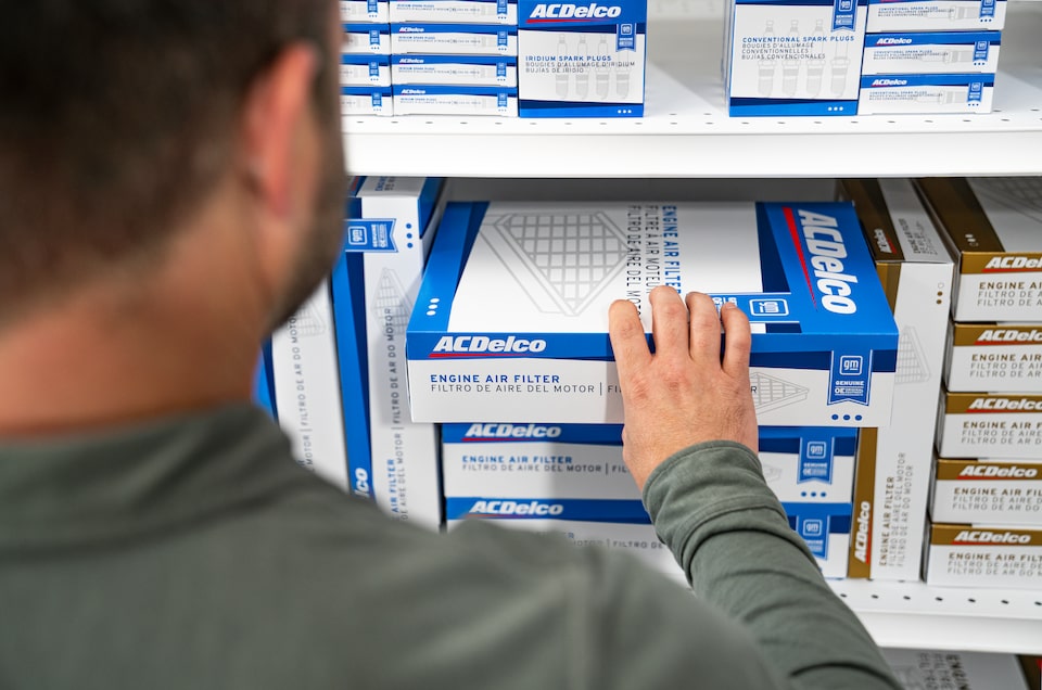 A Man Grabbing an Engine Air Filter in a Box