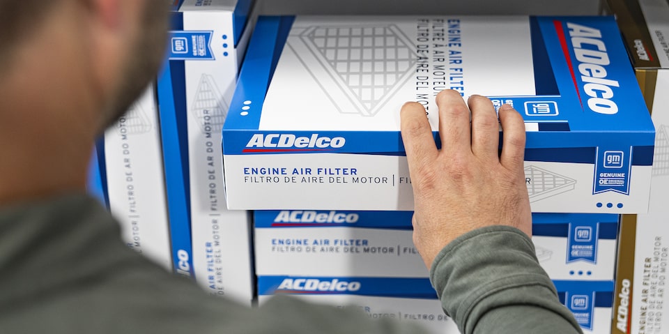 A Man Grabbing an Engine Air Filter in a Box