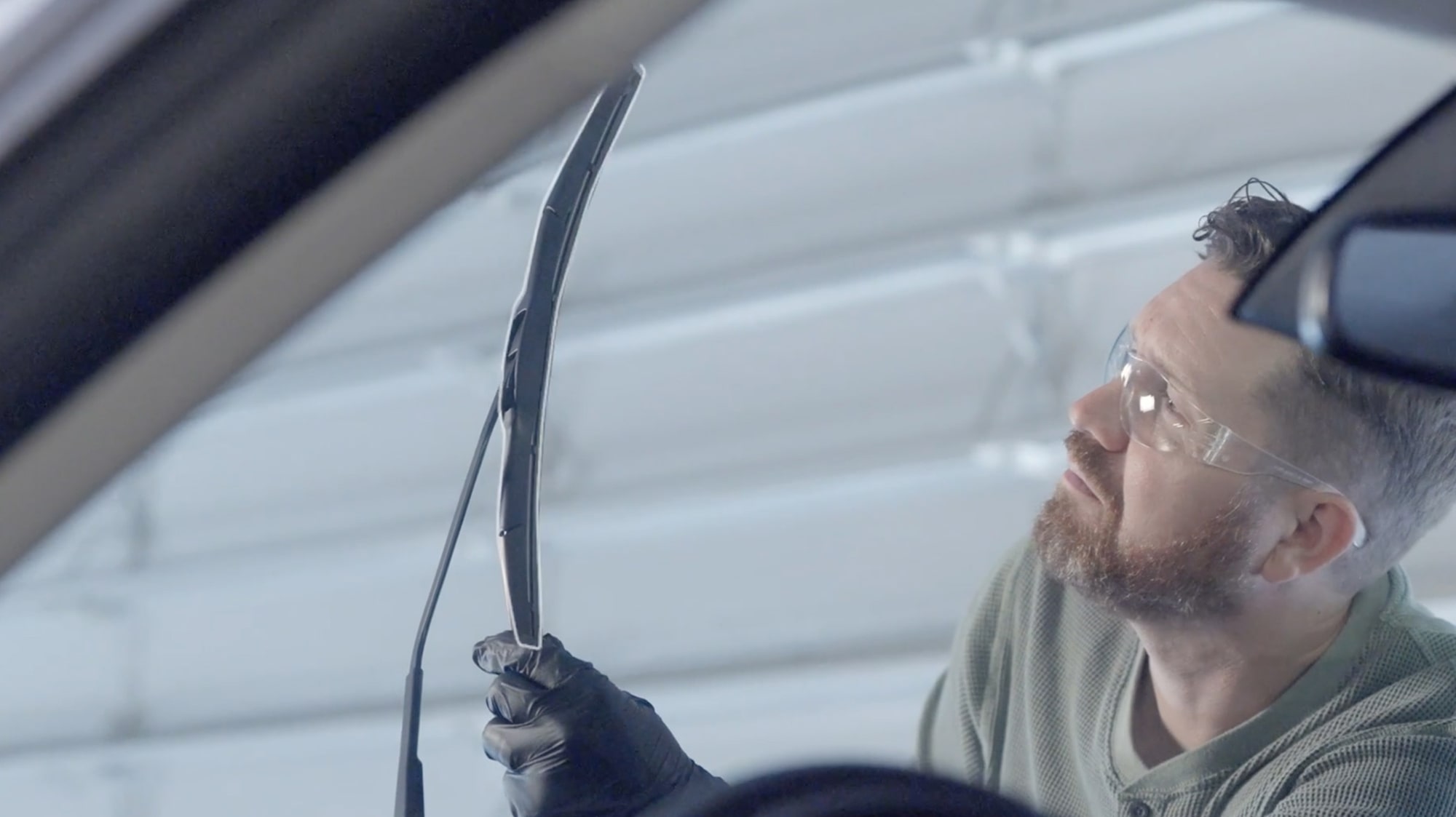 A Mechanic Is Observing a Black Wiper Blade
