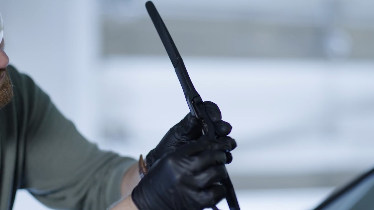 A Mechanic Is Fixing a Windshield Blade in a Car