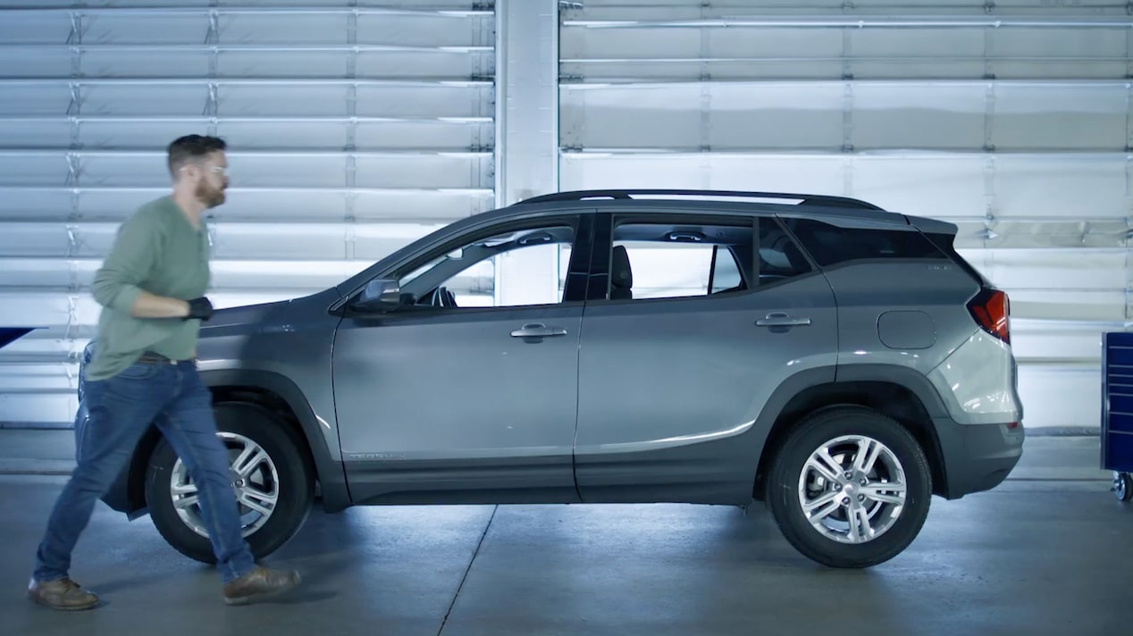 Side View of a Gray SUV with a Mechanic Working on It