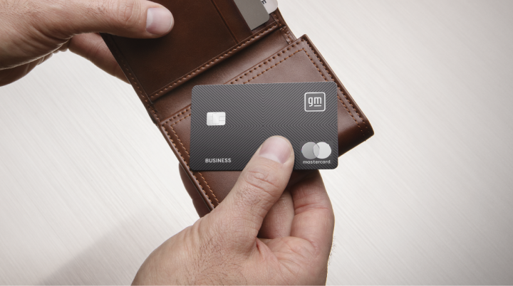 Hand removing a GM Business™ Mastercard® from a wallet, symbolizing everyday business purchasing power.