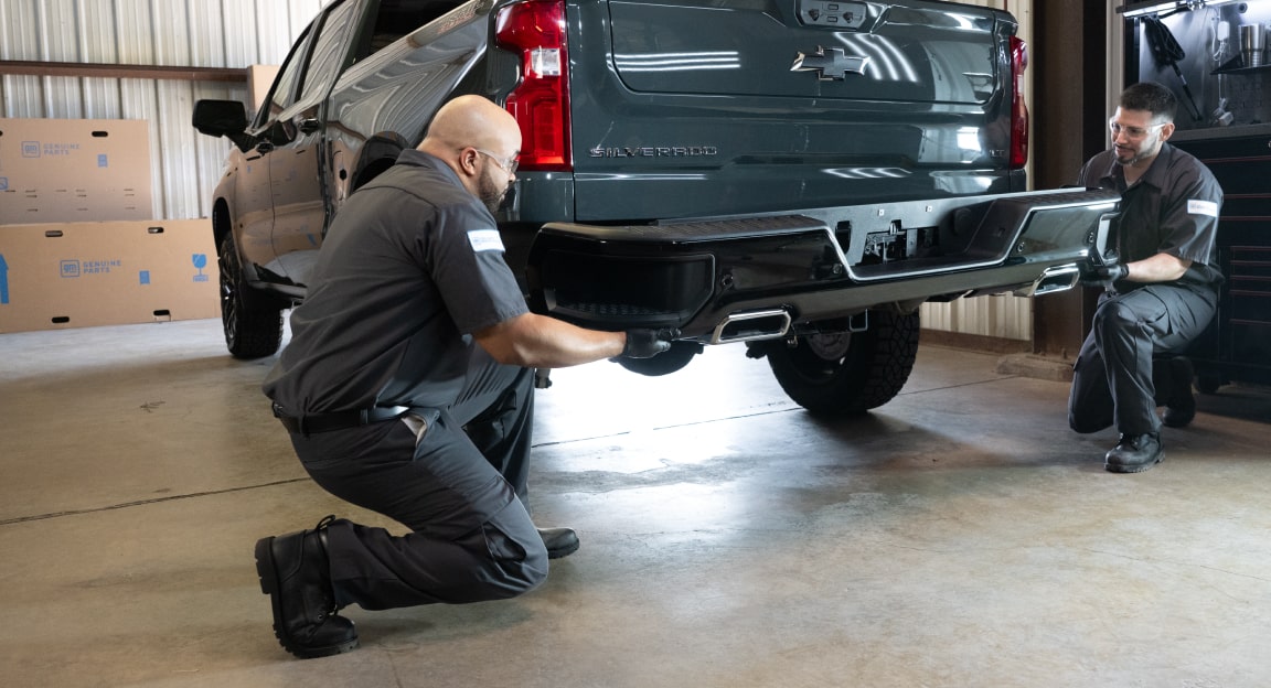 A Service Technician Working on the Rear Side of a GMC Truck