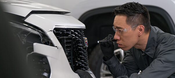 GM Technician Inspecting a Damaged Grille on a Vehicle