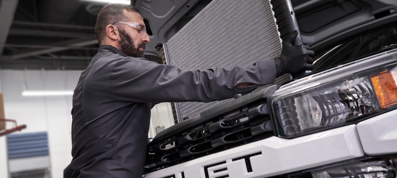 GM Technician Replacing a Radiator Part in a Vehicle