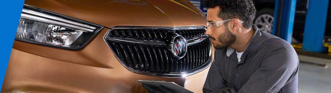 GM Technician Inspecting the Front-End of a Vehicle