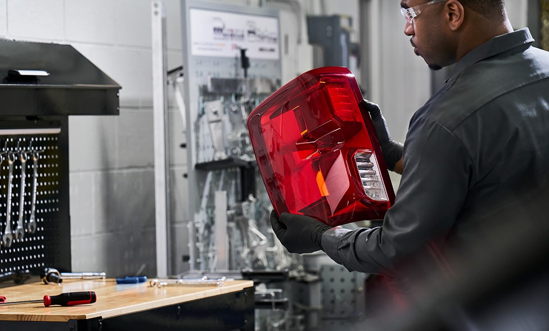 A Mechanic is Inspecting the Taillight of a Vehicle
