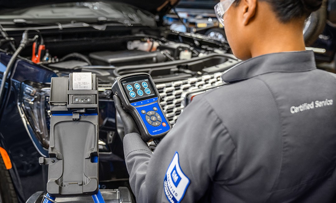 A Mechanic Is Looking at a Meter When Working on a Vehicle