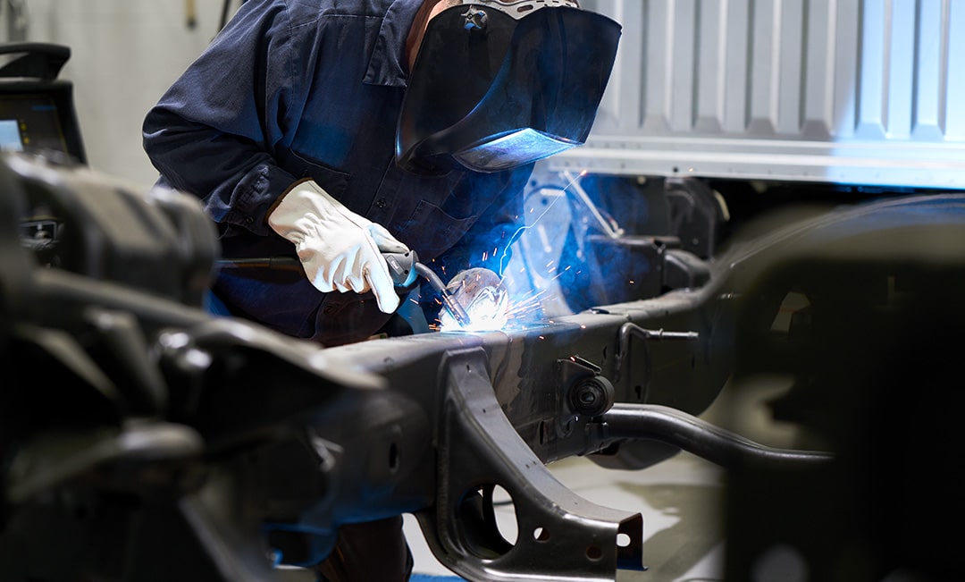 A Mechanic Welding a Vehicle While Wearing a Protective Helmet