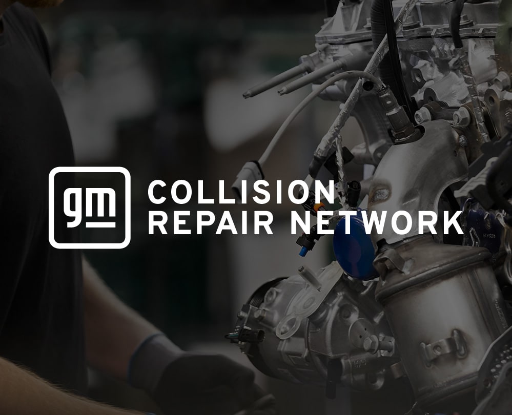 An Engine Suspended While a Mechanic is Working on It
