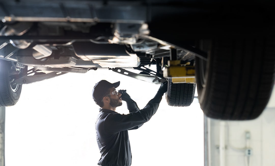 A Mechanic is Looking at a Meter When Working on a Vehicle