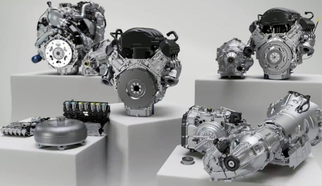 Various GM Genuine Engines Sitting on Display with Text Overlay "3-year/100,000-mile limited warranty covering both parts and labor"